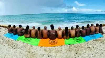 Black Naturist Association members sitting on beach